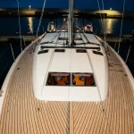 Vista di notte da prua della coperta della barca a vela Jeanneau Sun Odyssey 490 "Chaos" di Spartivento Charter ormeggiata in porto