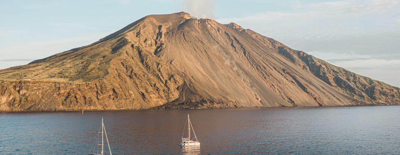 Barca a vela e cataramano che navigano nei pressi della Sciara del Fuoco di Stromboli alle Isole Eolie, Sicilia